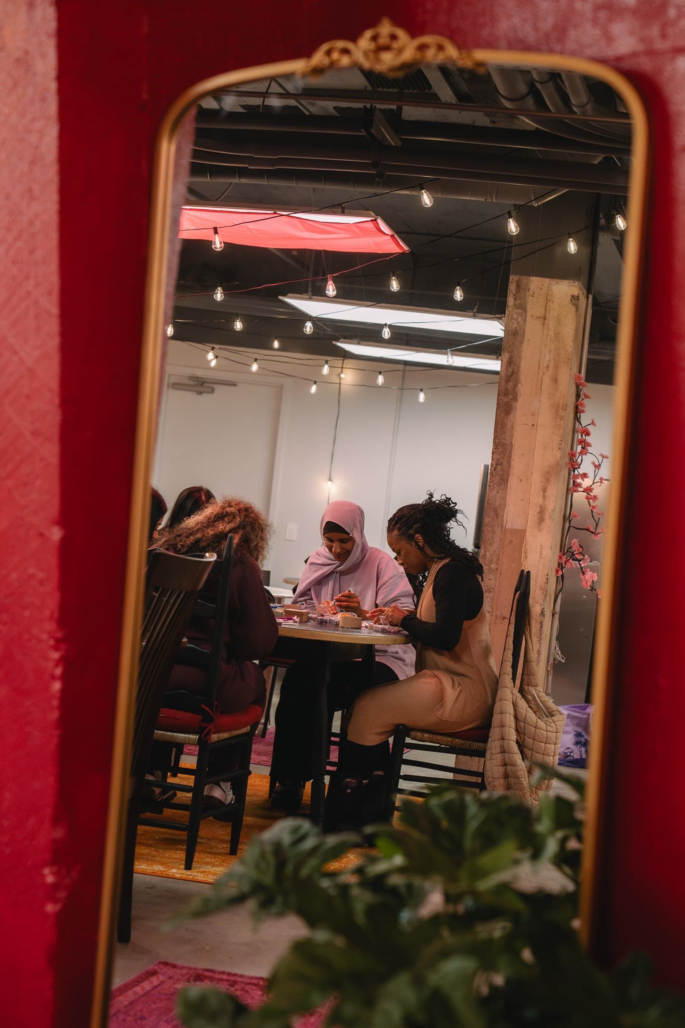 Guests crafting at a table, seen in a gold mirror